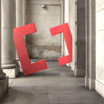 Sculpture of Creative Cardiff's logo made up of two red halves of a square divided to look like angular 'C' shapes.