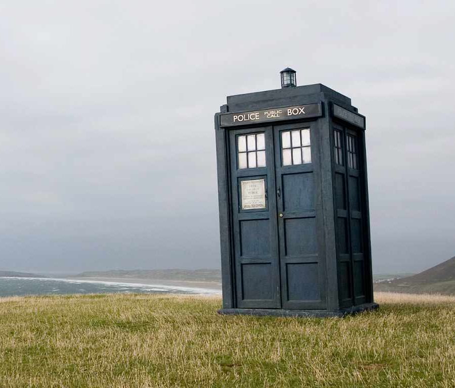 Doctor Who's Police Box Tardis on the headland of Rhossili Bay, with beach and sea behind