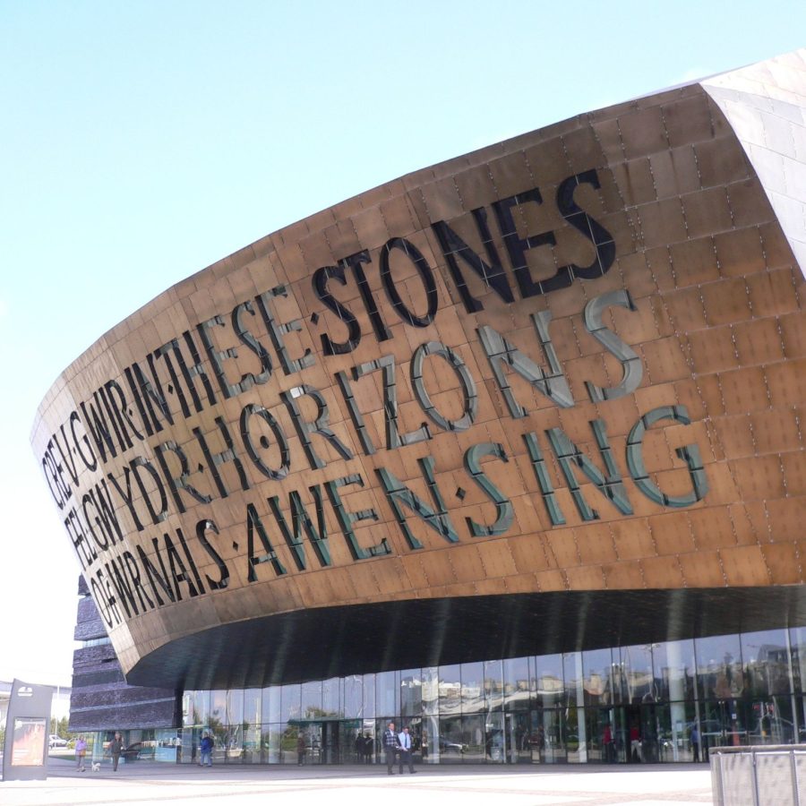 A view of the Wales Millennium Centre in Cardiff, with its bronze-coloured dome and poem in massive letters.