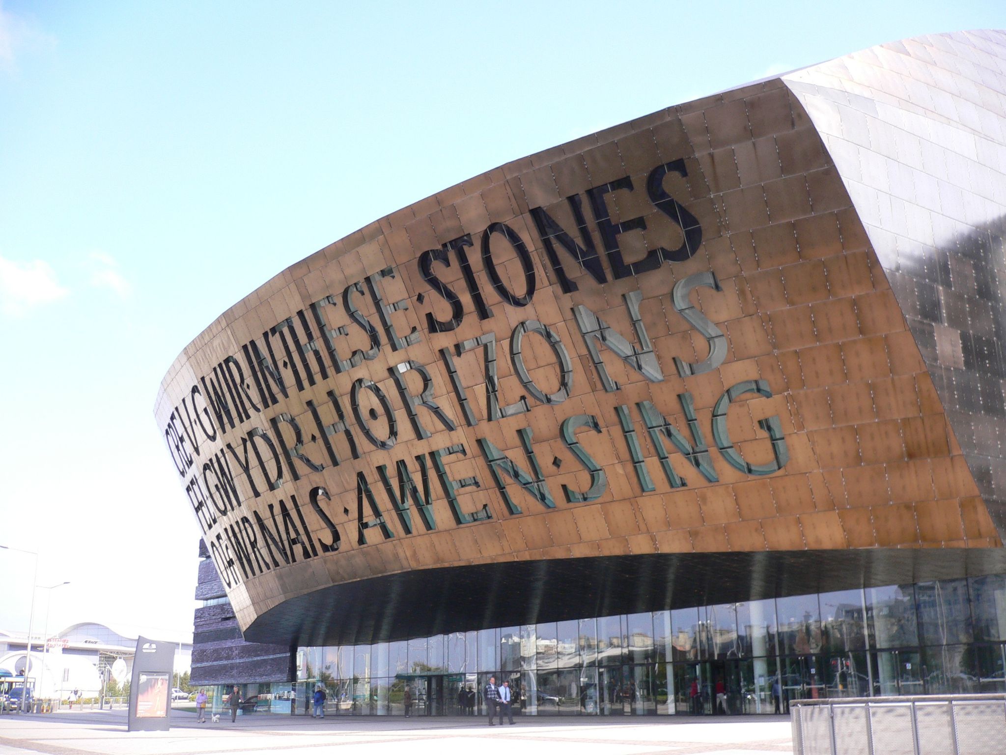 A view of the Wales Millennium Centre in Cardiff, with its bronze-coloured dome and poem in massive letters.